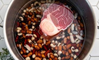 Выложите подготовленную фасоль и мясо и залейте холодной водой