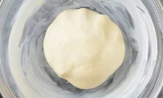 Поместите тесто в смазанную маслом миску в тепленькую духовку