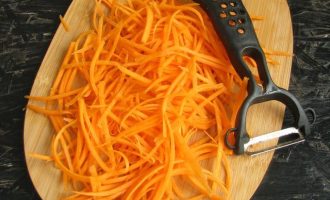 Оранжевый очищенный корнеплод натрите на терке, предназначенной для корейской морковки. Если соломка будет слишком длинная, то разрежьте на две или три части.