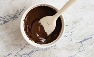 Остальную часть шоколада растопите в микроволновке порциями по 30 секунд, пока не останется нерасплавленных остатков