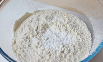 Для приготовления домашнего хлеба с сыром подготовьте все компоненты. В качестве сыра возьмите Пармезан или Эмменталь. А остальные ингредиенты согласно представленной рецептуре. Далее просейте пшеничную муку в миску и всыпьте соль и разрыхлитель.