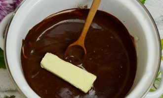 Добавьте в шоколадную глазурь сливочное масло и размешайте до однородности.