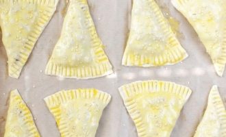 Смажьте верх эмпанадас яичной смесью и посыпьте по желанию кунжутом