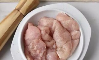 Подготовленное филе птицы переложите в миску и приправьте солью и перцем