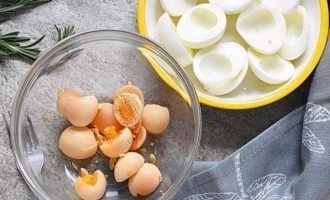 Чтобы удалить яичные желтки, надавите на яичную половину и вытащите яичные желтки в миску