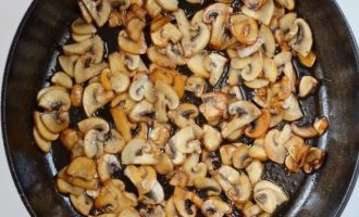 Добавьте нарезанные грибы в ту же сковороду и готовьте, пока они не подрумянятся