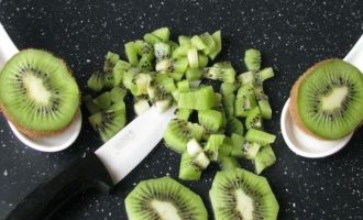Зеленые плоды киви хорошо промойте, очистите от кожуры и мелко-мелко нарежьте в виде кубиков.