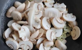 К чесноку добавьте грибы и продолжайте поджаривать