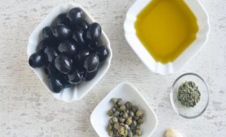 Подготовьте маслины, сушеный орегано, каперсы, оливковое масло и чеснок