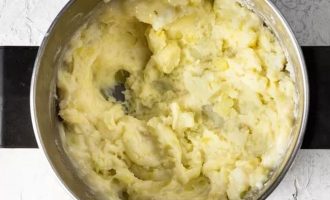 Верните картофель в кастрюлю и протрите его вместе с молоком и маслом до состояния пюре