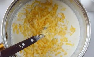 Добавьте в соус тертый сыр, чеснок и горчицу
