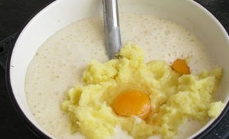 Пока картофельное пюре остывает, посмотрите, готова ли опара. Она считается готовой, если увеличится в обьеме в три раза и начнет оседать. В готовую опару, вылейте оставшееся молоко, сверху выложите картофельное пюре и вбейте два яйца.