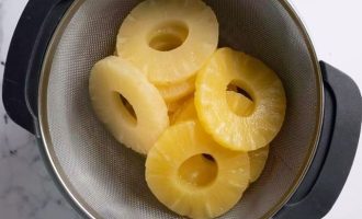 Возьмите консервируемые ананасы, слейте через дуршлаг сок, а колечки от ананасов выложите на салфетки и подсушите на воздухе.