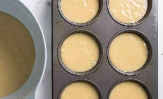 Заполните подготовленные чашки тестом для кексов с ананасами на две трети.