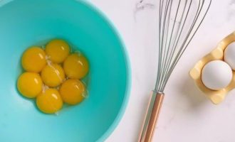 В отдельной миске взбейте яичные желтки и два яйца.