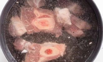 Мясо говядины на кости нарубите на отдельные куски, залейте холодной водой и поставьте варить мясо-костный бульон
