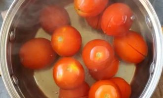 Как только вода закипит, обдайте помидоры кипятком