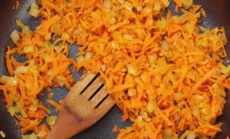 Тем временем разогрейте в сковороде 2 столовых ложки растительного масла, затем добавьте нарезанный лук и натертую морковь и пассеруйте на слабом огне 7-10 минут до мягкости