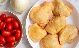 Вначале подготовьте все ингредиенты для приготовления куриных бедрышек с помидорами и луком