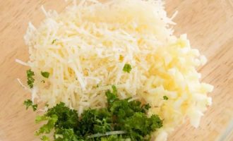 Для заливки в небольшой посуде смешайте сыр пармезан, измельченный чеснок и петрушку.