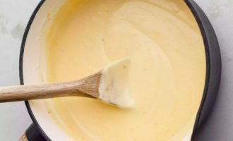 Сыр натрите на терке, введите в общую массу и готовьте, помешивая, пока сыр не растает, а соус не станет гладким и хорошо перемешанным.