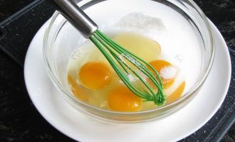 Далее разбейте в миску три яйца, всыпьте сахар и слегка взбейте.