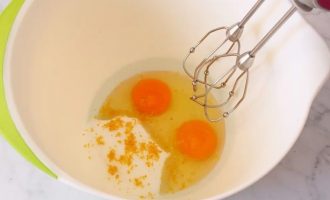 В рабочую емкость миксера разбейте два яйца, всыпьте 125 грамм сахара и цедру лимона