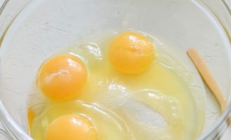В отдельную посуду вбейте 3 куриных яйца, всыпьте один стакан сахара и две щепотки соли.