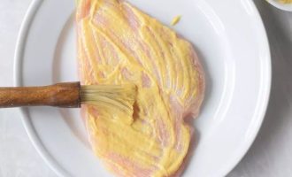 Куриное филе нарежьте на куски, слегка отбейте и смажьте дижонской горчицей с обеих сторон.