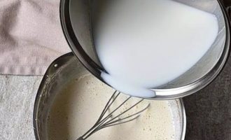 Медленно тонкой струйкой влить горячее молоко в яично-желтковую смесь, непрерывно взбивая