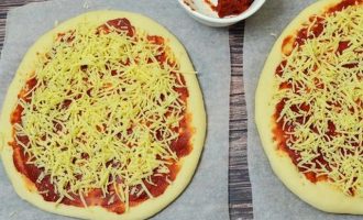 Сверху на томатную пасту разложите натертый на терке твердый сыр.
