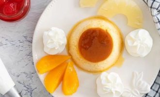 Для сборки десерта выложите флан в центр тарелки и украсьте его по вкусу взбитыми сливками, персиком в сиропе, ананасом в сиропе