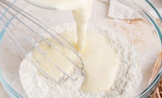 Добавьте смесь йогурта и яиц к мучной смеси и хорошо перемешайте.