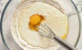 Взбейте 1 яйцо, подготовленное молоко и 2 столовые ложки растопленного сливочного масла с сухими ингредиентами, пока они не смешаются