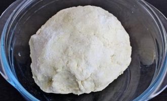 После всыпать соль, разрыхлитель, просеянную пшеничную муку и замесить тесто. Замешенное тесто для лепешек с сыром и творогом оставить на 20 минут на рабочем столе, а потом завернуть аккуратно в пленку и отправить в холодильник на 35 минут.