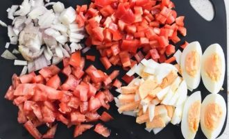 Нарежьте для салата лук, помидоры, красный перец и яйца