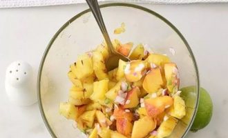 Смешайте кусочки жареного ананаса, нарезанные персики, измельченный перец халапеньо, красный лук сок 1 лайма и приправьте солью