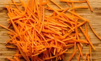 Очистите морковь и нарежьте аккуратно вручную соломкой или примените приспособление для корейской моркови.
