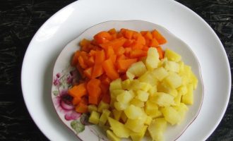 Картофель и морковь хорошо промойте в воде, переложите в кастрюлю, залейте горячей водой, до готовности. В конце варки подсолите. Овощи не переваривайте, так как потом не получится красивая нарезка. Воду слейте, дайте овощам остыть, а после очистите от кожицы. Нарежьте морковь и картофель в виде кубиков.
