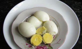 Яйца достать из холодильника, дать постоять при комнатной температуре (чтобы потом при варке не лопнули), промыть в слегка тепленькой воде и отварить вкрутую. Достаточно варить их после закипания воды 10 минут.