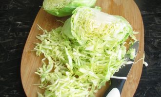 Молоденькую капусту разрежьте на 4 части и нашинкуйте соломкой.