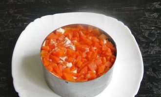 После огурцов и оливок прослойте вновь майонезом, а потом разложите акуратно кубики моркови.