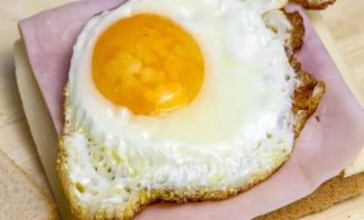 Поджарьте яйцо и положите его на ветчину и сыр