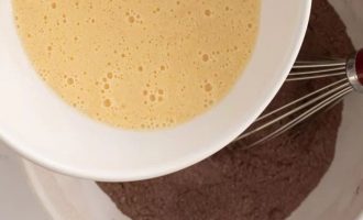 Смешайте белый и коричневый сахар и добавьте подсолнечное масло, пахту, воду, яйцо и ванильную пасту