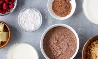 Для приготовления шоколадного пирога с пудингом и малиной подготовьте все ингредиенты. Крекеры желательно подберите, которые приготовлены из муки грубого помола. Для получения взбитых сливок возьмите их с жирностью не менее 40% и сахарную пудру.