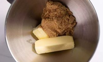 В миску выложите коричневый сахар и размягченное сливочное масло.