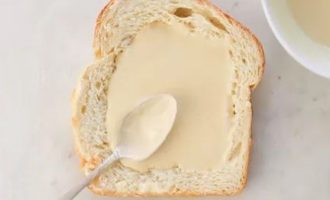 Вылейте половину йогуртовой смеси на хлеб, распределив его ровным слоем.
