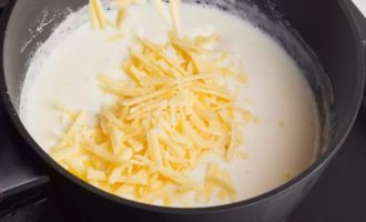 Добавьте тертый сыр на терке и продолжайте варить, помешивая, пока сыр не растает.