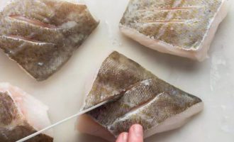 Подготовленное филе рыбы нарежьте на порционные кусочки и на поверхности кожи выполните при помощи ножа надрезы.