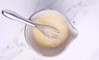 В удобной другой небольшой миске смешайте молоко, яйцо, рапсовое масло и перемешайте при помощи ручного венчика.
